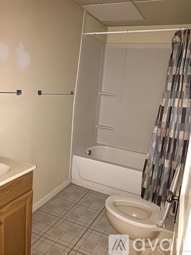 A bathroom with a toilet, sink, and shower.