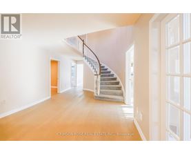 A spacious room with a staircase leading to the upper floor.