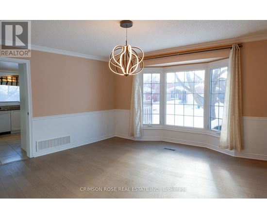 A large empty room with a chandelier hanging from the ceiling.