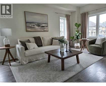 A living room with a white couch, a coffee table, and a painting on the wall.