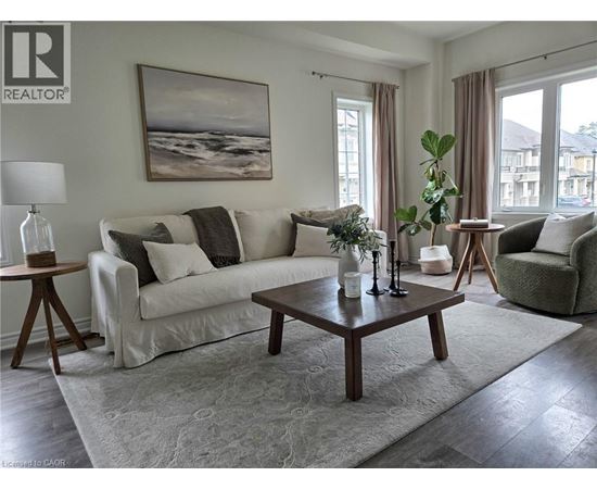 A living room with a white couch, a coffee table, and a painting on the wall.