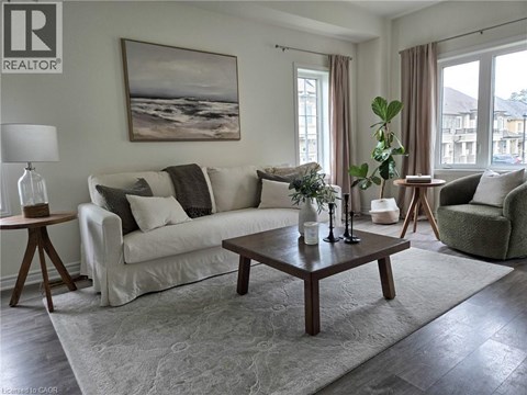 A living room with a white couch, a coffee table, and a painting on the wall.