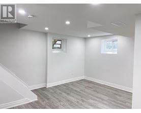 A room with a grey carpet and white walls.