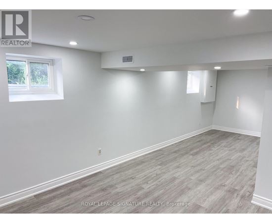 A white room with a window and a grey floor.