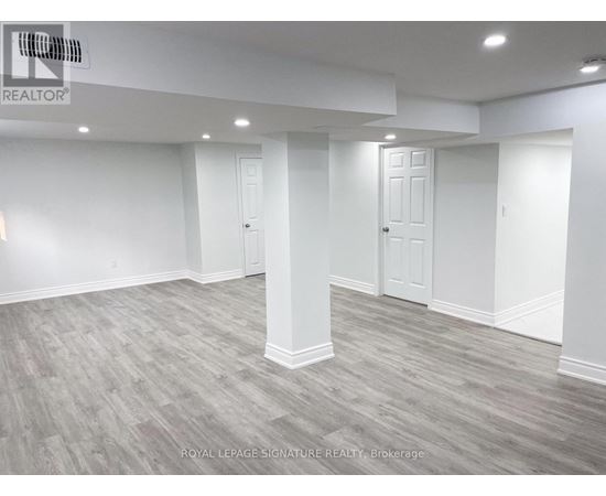A spacious room with grey flooring and white walls.