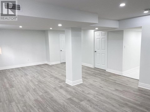A spacious room with grey flooring and white walls.