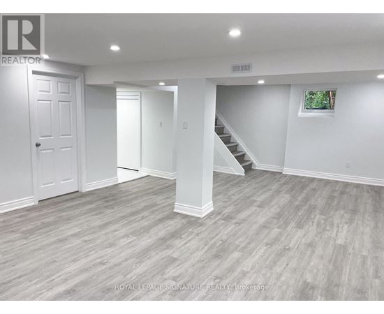 A spacious room with a staircase and a window.