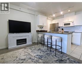 A kitchen with white cabinets and a black television.