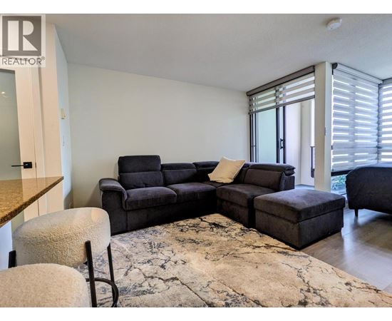 A living room with a grey sofa and a rug.