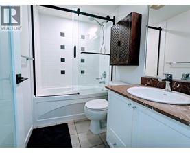 A bathroom with a toilet, sink, and shower.