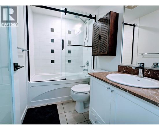 A bathroom with a toilet, sink, and shower.