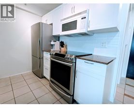 A kitchen with white cabinets and appliances.