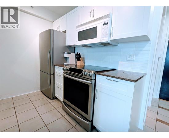 A kitchen with white cabinets and appliances.