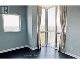 A room with a view of the city through large windows.