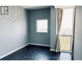A room with a window and a view of trees outside.