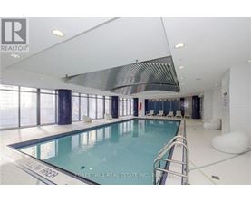 A swimming pool inside a building with a white ceiling.