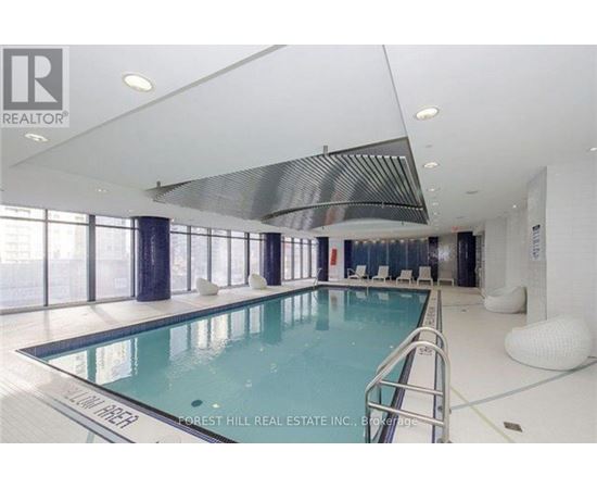 A swimming pool inside a building with a white ceiling.