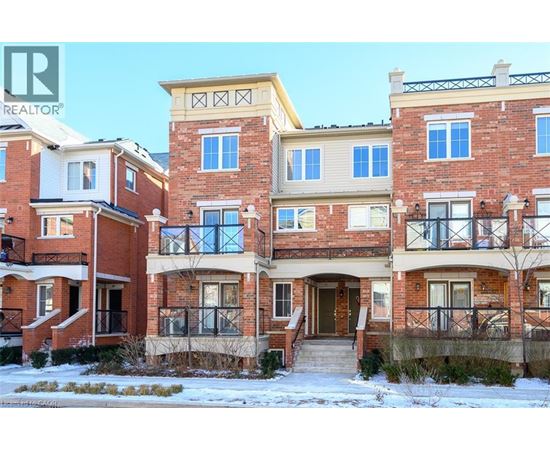 A row of red brick houses with a realtor logo in the corner.