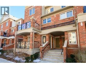 A red brick house with a balcony and a glass railing.