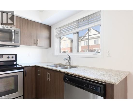 A kitchen with brown cabinets and a granite countertop.