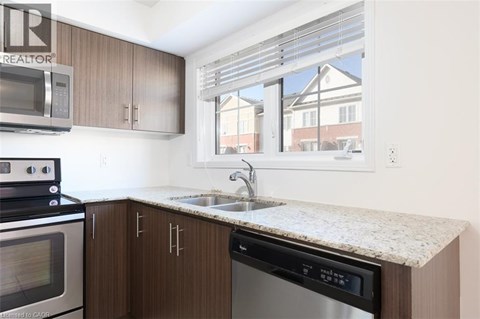 A kitchen with brown cabinets and a granite countertop.