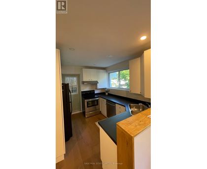 A kitchen with a black counter top and white cabinets.
