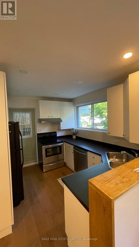 A kitchen with a black counter top and white cabinets.