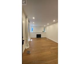 A room with a fireplace and wooden flooring.