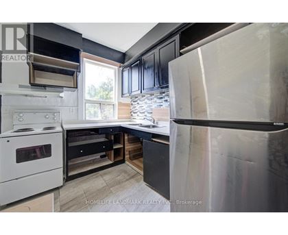 A modern kitchen with a white stove and black cabinets.