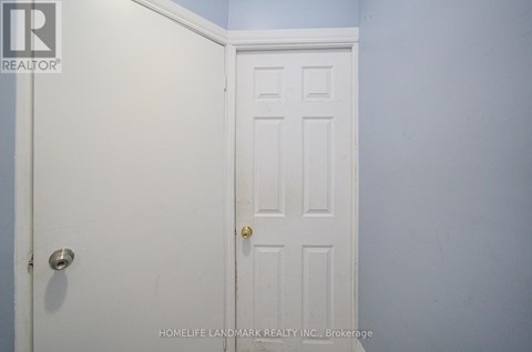 A white door with a gold handle is in a room with blue walls.