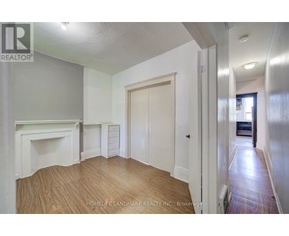 A room with a fireplace and wooden floors is for sale.