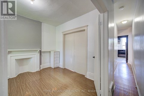 A room with a fireplace and wooden floors is for sale.