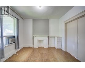A room with a fireplace and a window with a grey curtain.