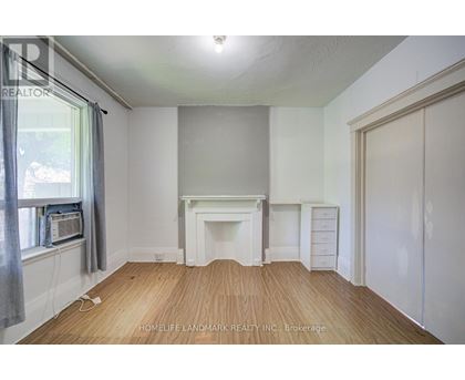 A room with a fireplace and a window with a grey curtain.