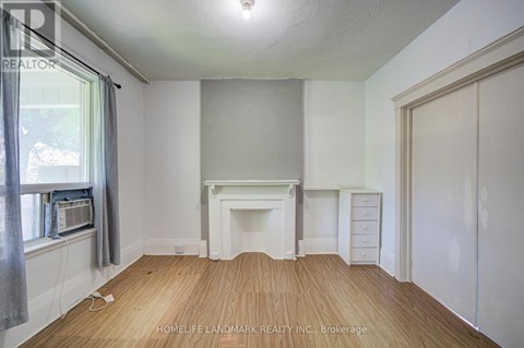 A room with a fireplace and a window with a grey curtain.