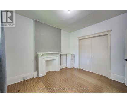A room with a fireplace and wood flooring.