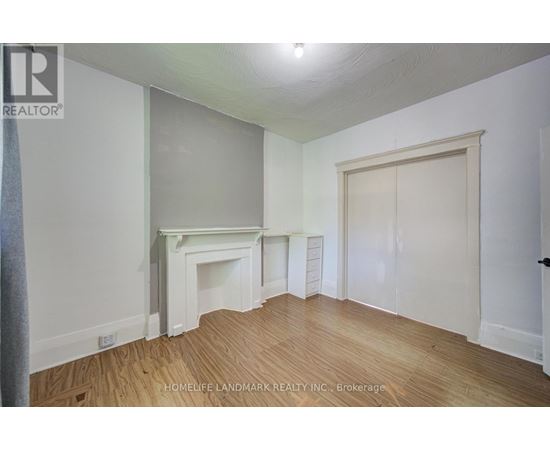 A room with a fireplace and wood flooring.