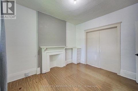 A room with a fireplace and wood flooring.