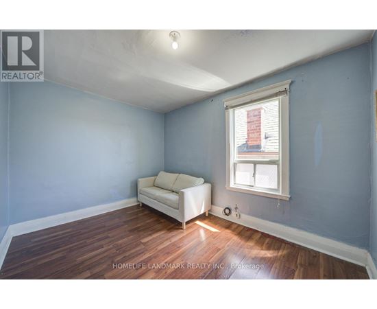 A room with a white couch and a window with blinds.