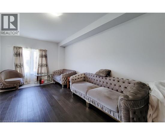 A living room with a brown sofa and a chair.