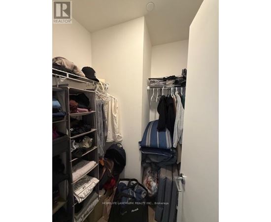 A small closet with clothes and a sign that says "Realtor".