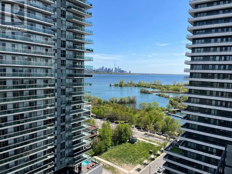 A view from a high-rise building looking out over a body of water with a distant industrial area.