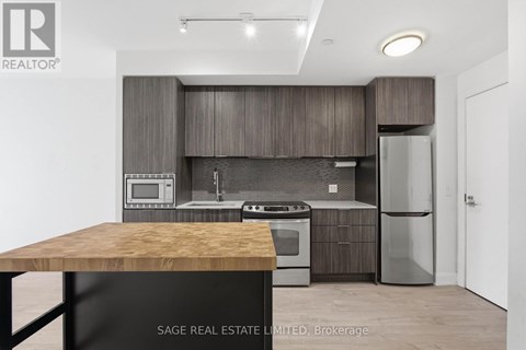 A modern kitchen with a wooden table and stainless steel appliances.