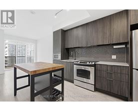 A modern kitchen with a wooden table and stainless steel appliances.