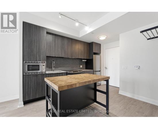A modern kitchen with dark wood cabinets and a wooden island.