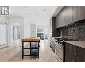 A modern kitchen with dark wood cabinets and a wooden island.