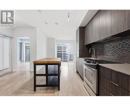 A modern kitchen with dark wood cabinets and a wooden island.