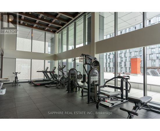 A gym with a variety of equipment including treadmills, weights, and exercise machines.