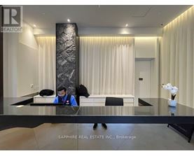 A real estate office with a reception desk and a person behind it.