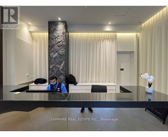 A real estate office with a reception desk and a person behind it.